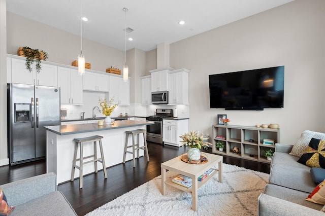 living area with recessed lighting, dark wood-type flooring, and a towering ceiling