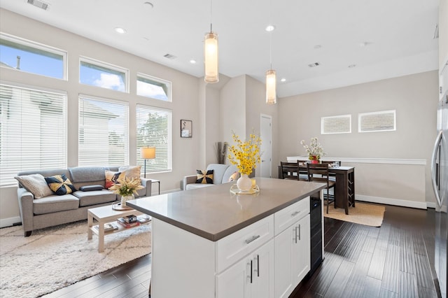 kitchen featuring dark wood finished floors, white cabinets, baseboards, and pendant lighting