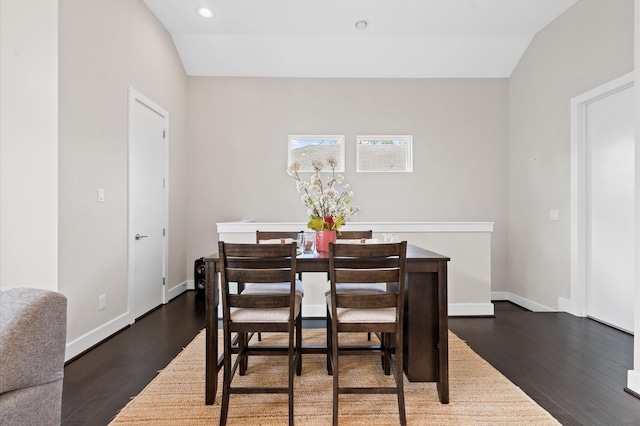 dining room with dark wood finished floors, lofted ceiling, and baseboards