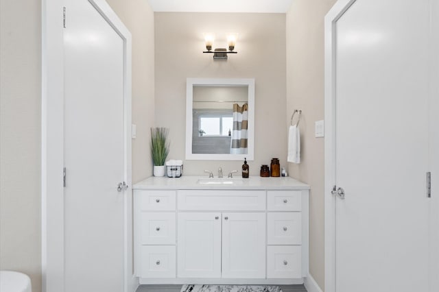 bathroom with vanity, a shower with shower curtain, and baseboards