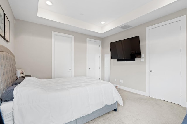 carpeted bedroom featuring recessed lighting, visible vents, a raised ceiling, and baseboards