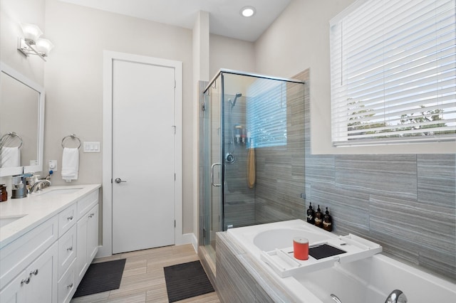 full bathroom featuring a sink, a garden tub, a stall shower, and double vanity