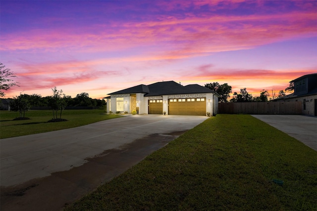 view of front facade with driveway, a front lawn, an attached garage, and fence