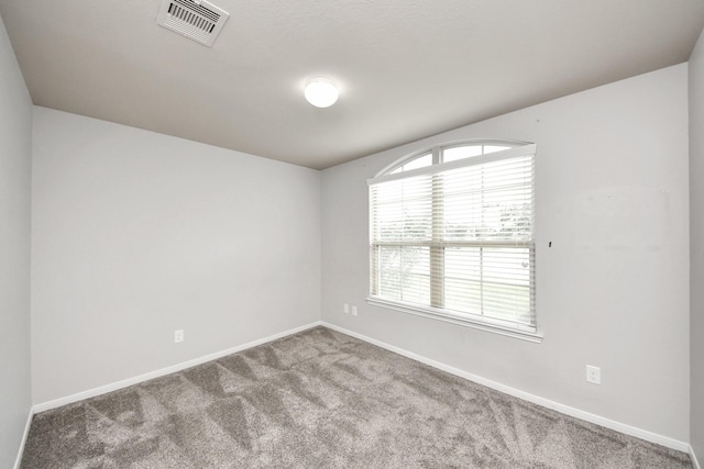 spare room with carpet, visible vents, and baseboards