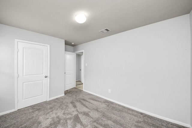 unfurnished bedroom with carpet, visible vents, and baseboards