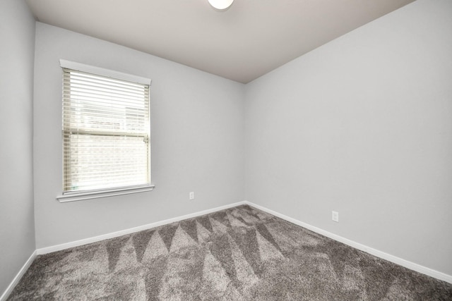 carpeted empty room featuring baseboards