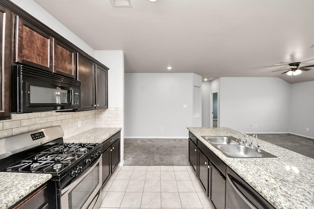 kitchen featuring light tile patterned floors, light carpet, a sink, appliances with stainless steel finishes, and decorative backsplash