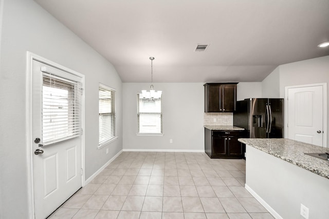 kitchen with tasteful backsplash, visible vents, black fridge with ice dispenser, vaulted ceiling, and a chandelier