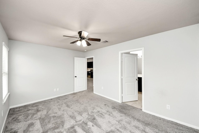 unfurnished bedroom with carpet floors, multiple windows, ceiling fan, and baseboards