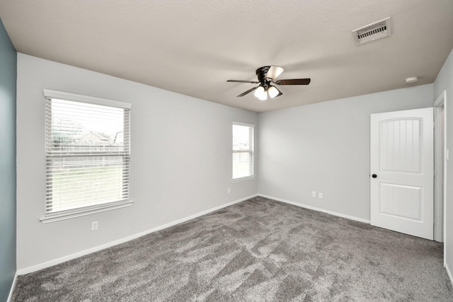 spare room with baseboards, visible vents, ceiling fan, a textured ceiling, and carpet flooring