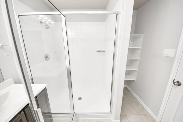 full bathroom featuring baseboards, a stall shower, vanity, and tile patterned floors