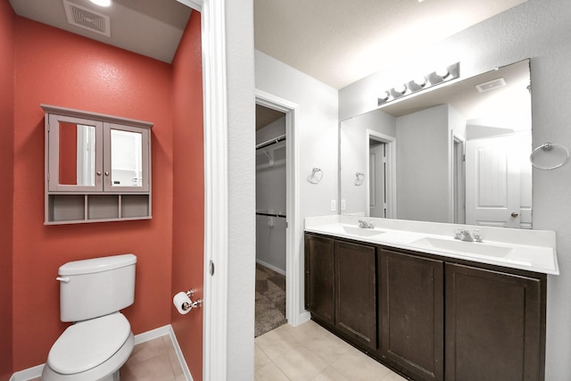 bathroom featuring visible vents, a sink, toilet, and double vanity