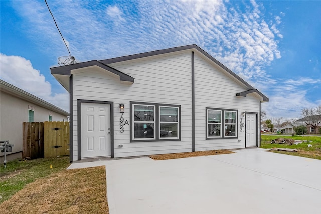 view of front of property featuring a patio area and fence