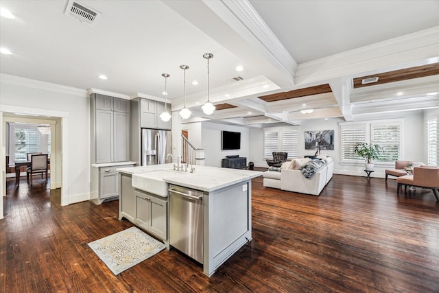 kitchen featuring beam ceiling, stainless steel appliances, gray cabinetry, open floor plan, and a sink