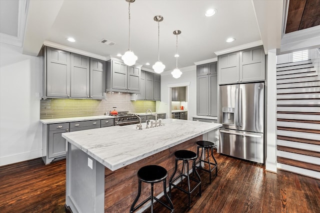 kitchen featuring gray cabinetry, a sink, visible vents, ornamental molding, and appliances with stainless steel finishes