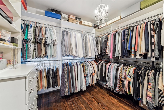 walk in closet with a notable chandelier and wood finished floors