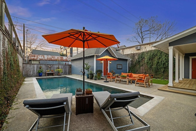 view of swimming pool featuring a fenced in pool, an outbuilding, outdoor lounge area, a patio area, and a fenced backyard