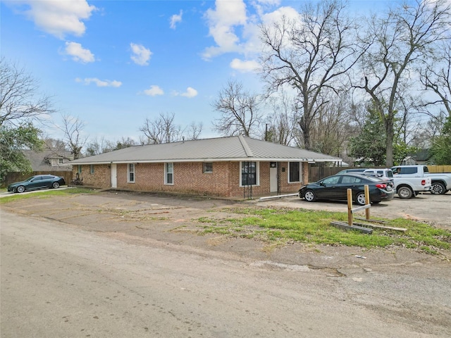 view of side of property with metal roof and brick siding