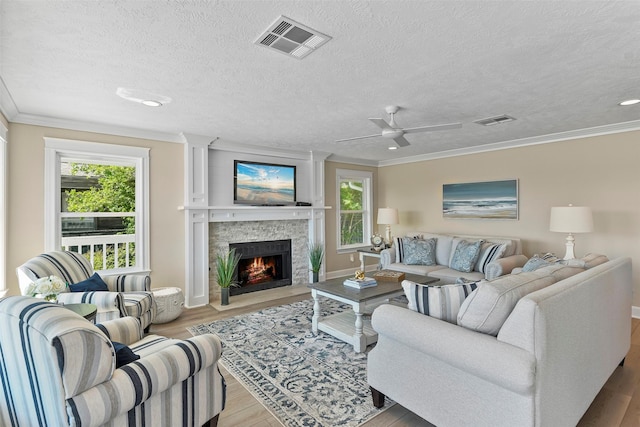 living room with crown molding, visible vents, and wood finished floors