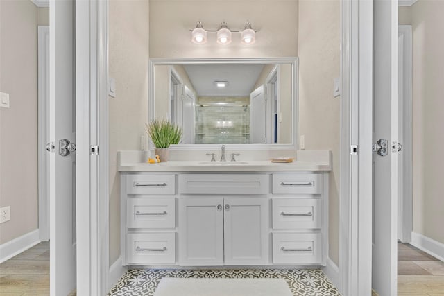 bathroom with an enclosed shower, vanity, and baseboards