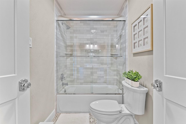 bathroom featuring enclosed tub / shower combo, a textured wall, and toilet