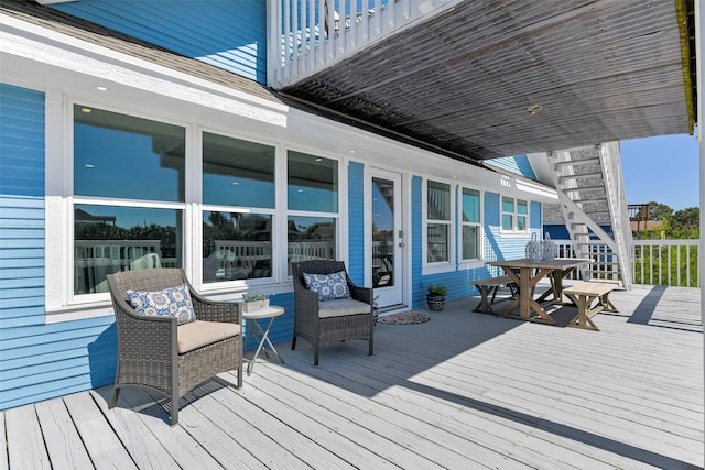 wooden deck featuring outdoor dining area and stairs