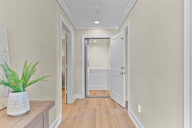 corridor featuring light wood-type flooring, baseboards, and ornamental molding