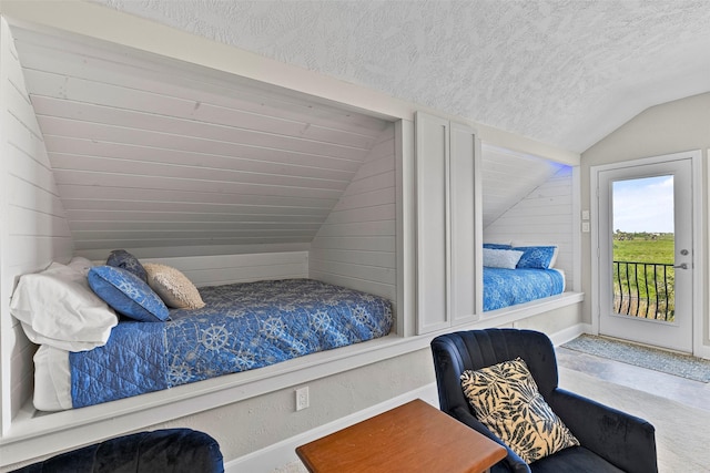 bedroom with lofted ceiling, access to outside, a textured ceiling, and baseboards