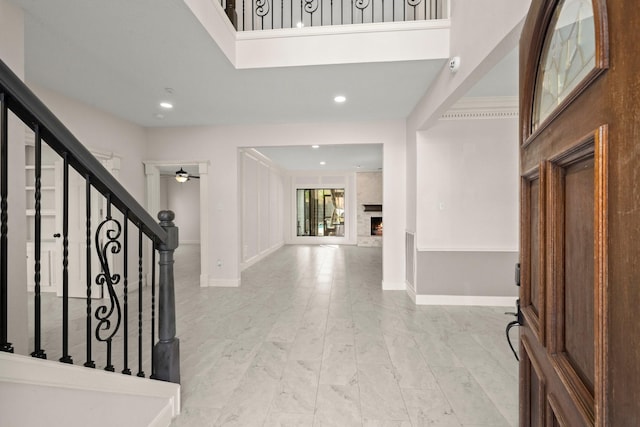 foyer with a fireplace, baseboards, stairs, and a ceiling fan