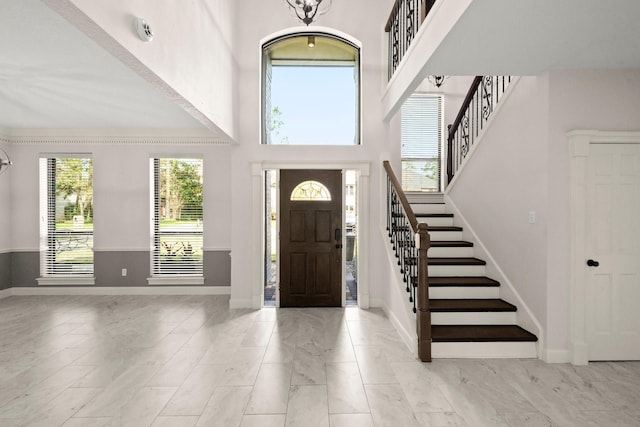 foyer with stairway, a high ceiling, and baseboards