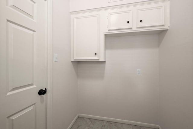 laundry area featuring baseboards and marble finish floor