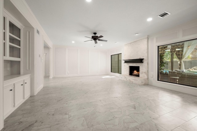 unfurnished living room featuring a decorative wall, a fireplace, visible vents, and marble finish floor