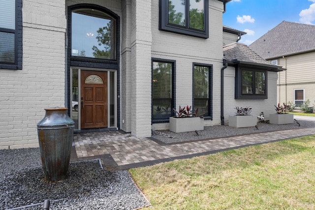 entrance to property featuring brick siding