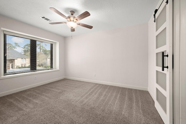 spare room featuring visible vents, carpet floors, and a textured ceiling