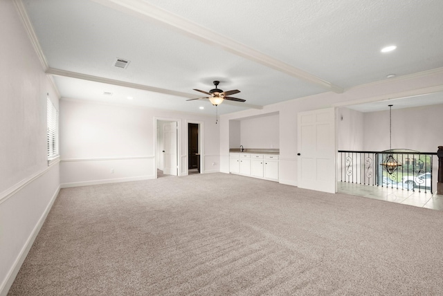 empty room featuring crown molding, visible vents, and carpet floors