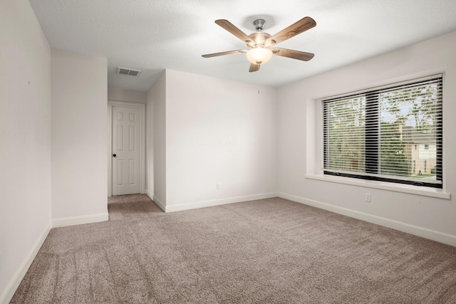 unfurnished room featuring visible vents, ceiling fan, baseboards, carpet flooring, and a textured ceiling