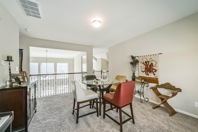 dining room featuring visible vents, light carpet, and baseboards