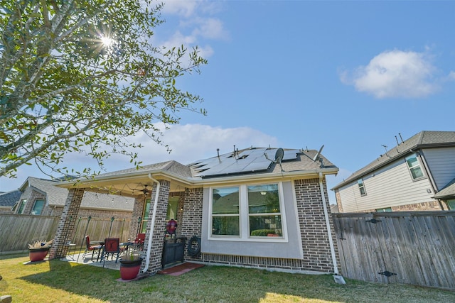 back of house with a patio area, brick siding, and a lawn