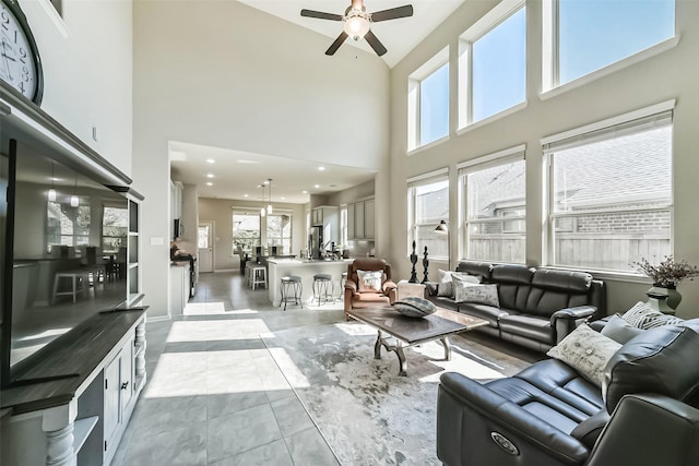 living area featuring a ceiling fan, light tile patterned flooring, and plenty of natural light