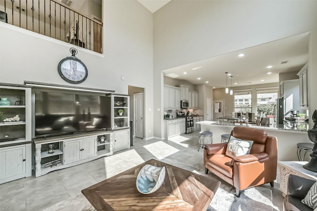 living area with recessed lighting, a towering ceiling, and light tile patterned floors