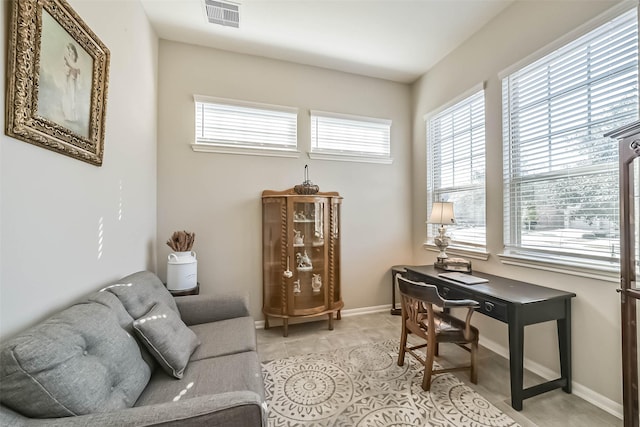 office space with light tile patterned floors, visible vents, and baseboards