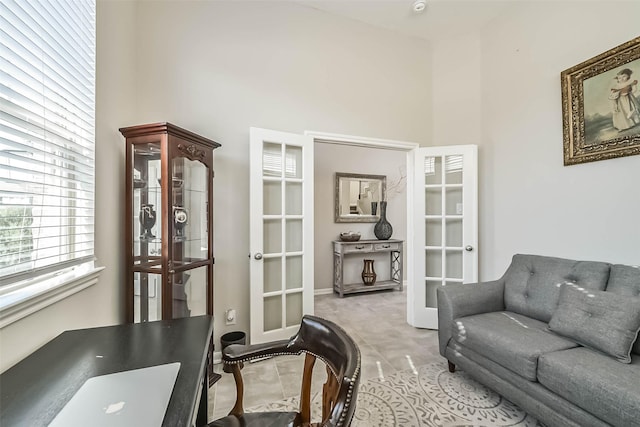 interior space with light tile patterned floors, a high ceiling, and french doors