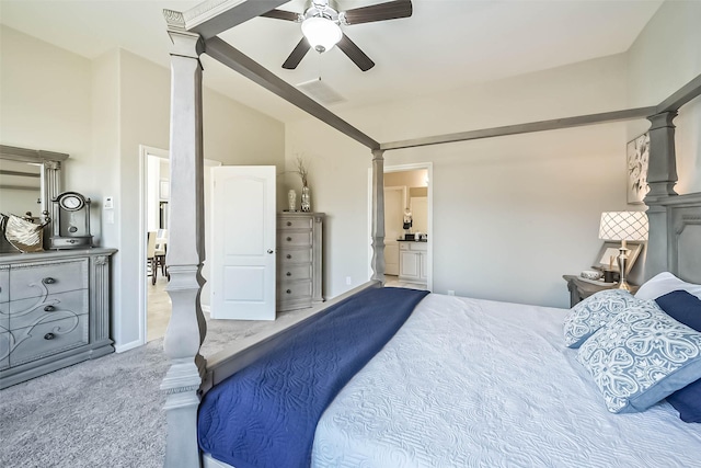 carpeted bedroom with decorative columns, lofted ceiling, visible vents, a ceiling fan, and connected bathroom