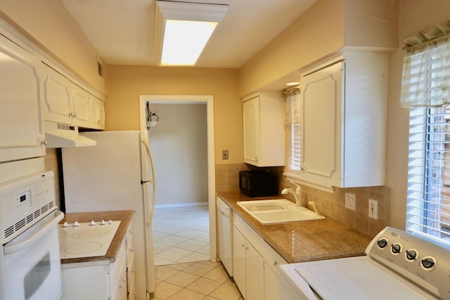 kitchen featuring washer / dryer, white appliances, a sink, and tasteful backsplash