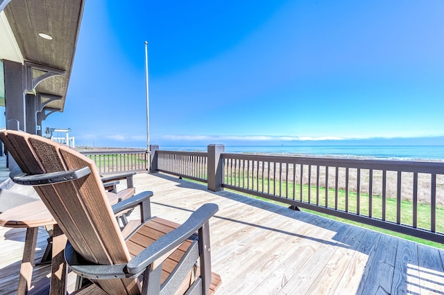 wooden deck with a water view and a beach view