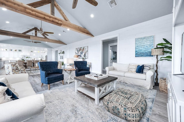 living area with high vaulted ceiling, beam ceiling, visible vents, and light wood finished floors