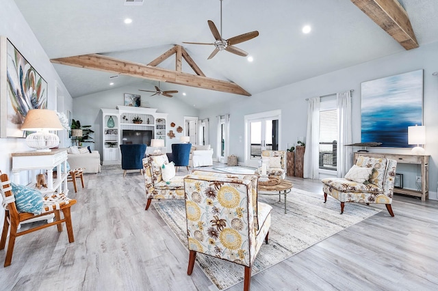 636 Villa Dr, Crystal Beach, TX 77650 - living area featuring a ceiling fan, a tiled fireplace, beamed ceiling, light wood-type flooring, and high vaulted ceiling