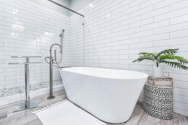636 Villa Dr, Crystal Beach, TX 77650 - full bath with a soaking tub, wood finished floors, and tile walls