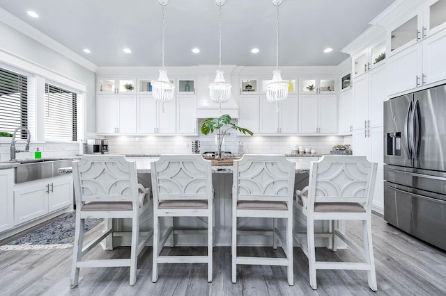 636 Villa Dr, Crystal Beach, TX 77650 - kitchen featuring ornamental molding, a sink, stainless steel fridge with ice dispenser, and a kitchen bar