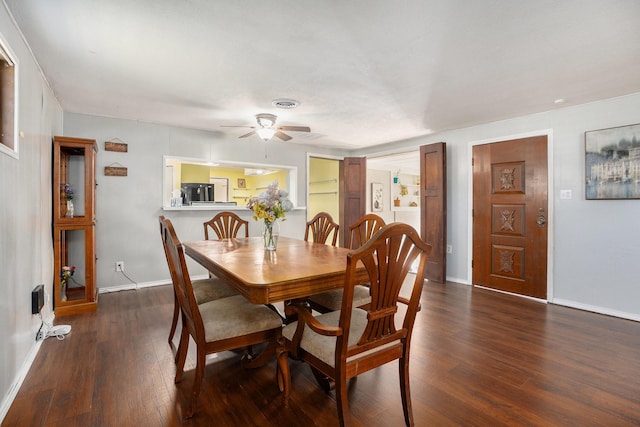 dining room featuring hardwood / wood-style flooring, ceiling fan, visible vents, and baseboards